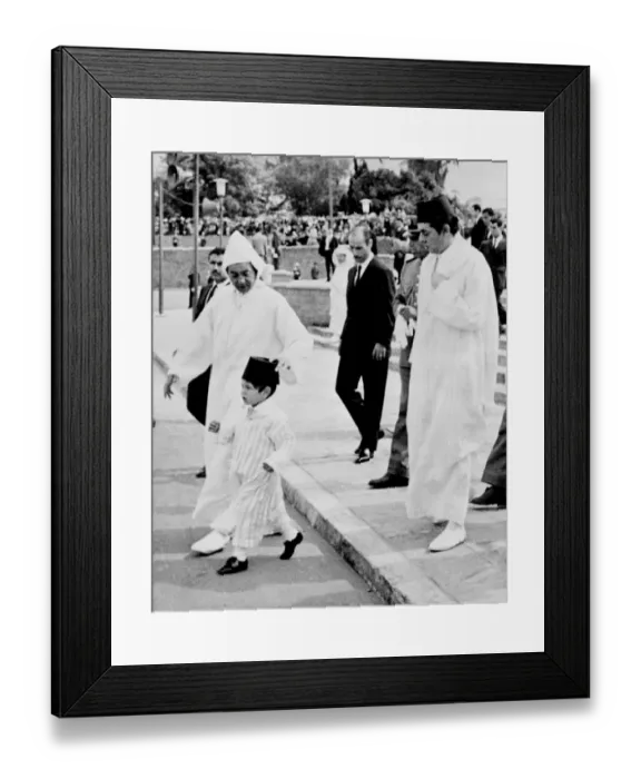 Framed Print : HM King Hassan II of Morocco adjusts the Fez worn by his young son Prince Sidi Mohammed Framed Print : HM King Hassan II of Morocco adjusts the Fez worn by his young son Prince Sidi Mohammed