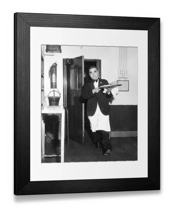 Framed Print : A waiter rushes through the kitchen door with a tray of food during the rush for orders at lunch