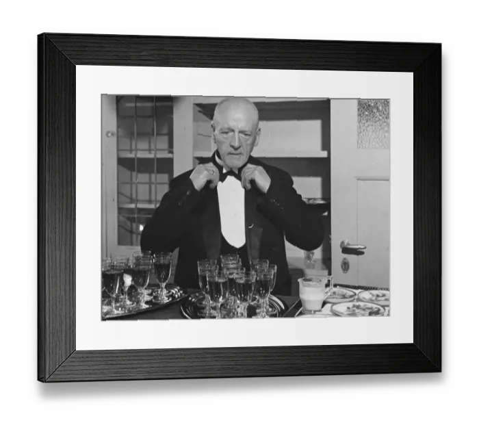 Framed Print : A wine waiter fixes his bow tie. undated Framed Print : A wine waiter fixes his bow tie. undated