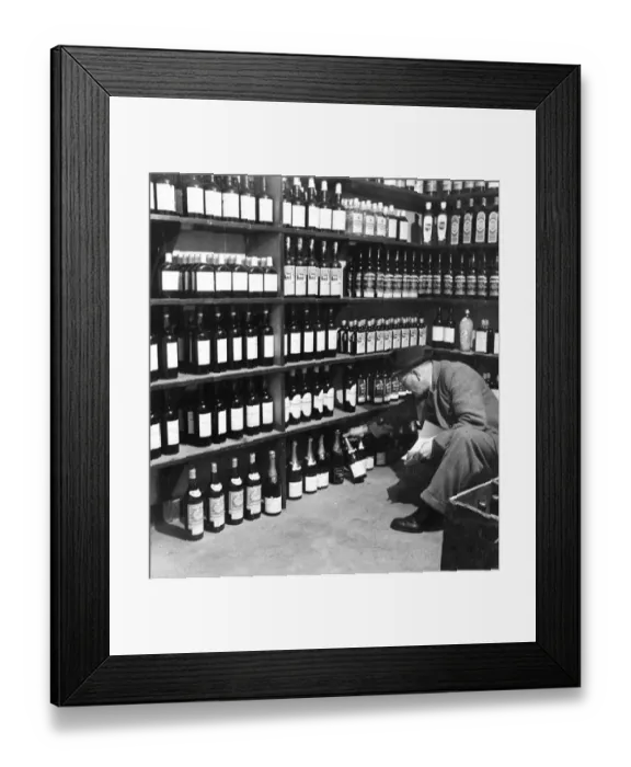 Framed Print : Man looking through the wines and spirits in the off licence department of the Globe Tavern Framed Print : Man looking through the wines and spirits in the off licence department of the Globe Tavern