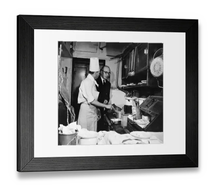Framed Print : In the kitchen of the restaurant car, the chef M. Roche consults the Maitre d Hotel about breakfast