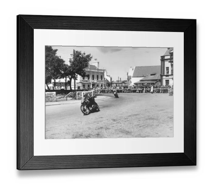 Framed Print : Competitors passing Ramsay Town Square at speed. Number 69 is W. J. Evans on AJS and number 90 is C