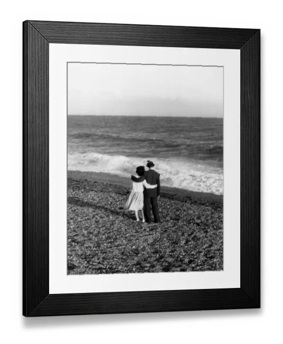 Framed Print : Young couple with their arms round each other enjoing the seaside Framed Print : Young couple with their arms round each other enjoing the seaside