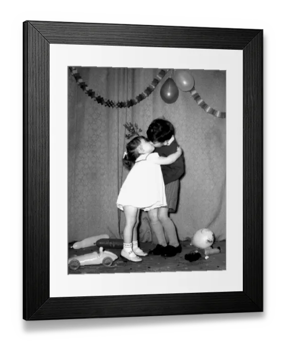 Framed Print : A little boy and girl kissing under the mistletoe at a Christmas party Framed Print : A little boy and girl kissing under the mistletoe at a Christmas party