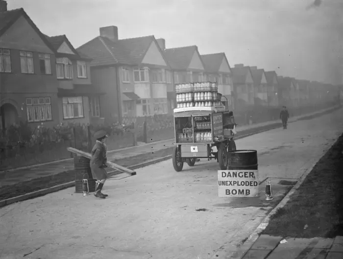 Framed Print : 9 November 1940 The milkman is allowed through the barrier to a street in his rounds