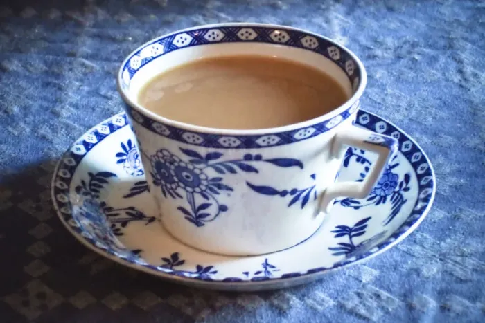 Framed Print : Antique blue and white cup and saucer of Indian tea with milk, on blue tablecloth Framed Print : Antique blue and white cup and saucer of Indian tea with milk, on blue tablecloth
