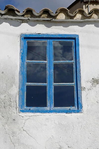 Blue framed window in white wall of Greek Cypriot house credit: Marie-Louise Avery