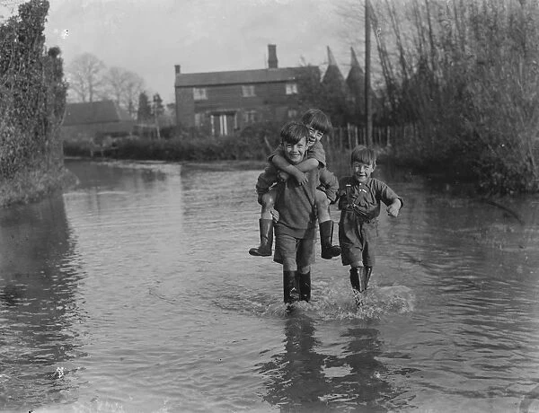 Boys work their way through the floods in Beltring, Kent. 1936