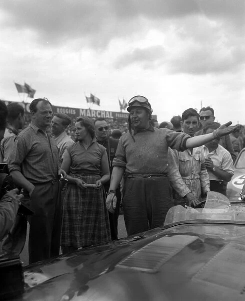 British Driver J Duncan Hamilton smiles and gestures after the victory he and teammate