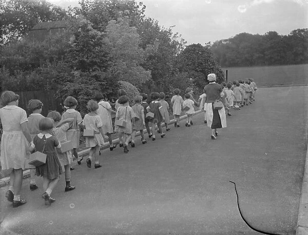 Children out with a nurse equipped with their gasmasks in Sidcup, Kent. 1939