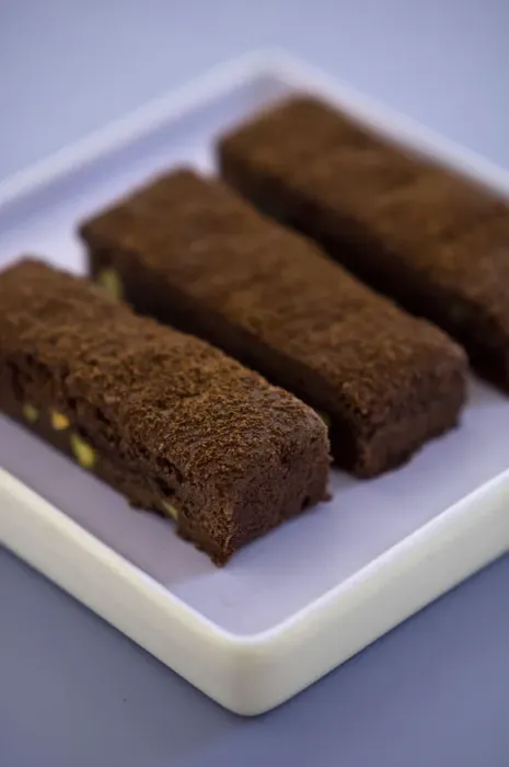 Framed Print : Three chocolate tray bake slices dusted with cocoa powder on square mauve plate credit Framed Print : Three chocolate tray bake slices dusted with cocoa powder on square mauve plate credit