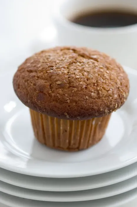 Framed Print : Cinnamon bran muffin on stack of white plates with cup of black coffee credit Framed Print : Cinnamon bran muffin on stack of white plates with cup of black coffee credit