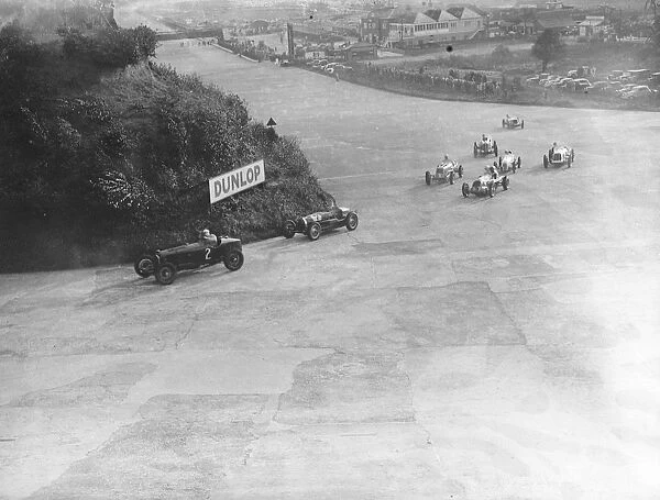 Cornering in mountain handicap at Brooklands. Cars taking the mountain corner in
