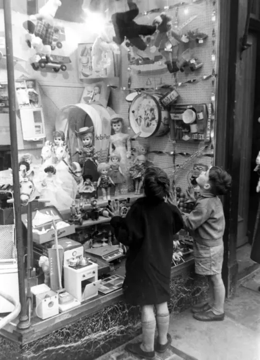Framed Print : A couple of children look longingly at the wonderful toys on display in their local