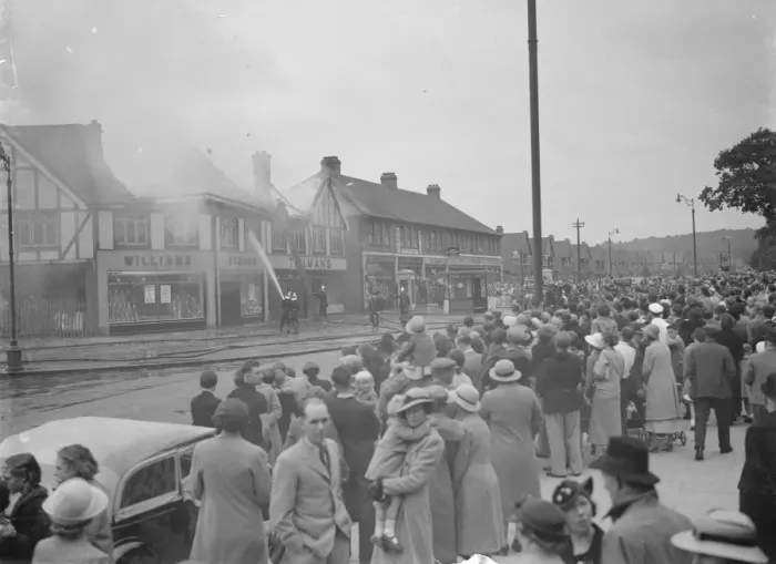 Framed Print : Crowds watch as firemen attempt to put out fires in a parade of shops in Welling, Kent Framed Print : Crowds watch as firemen attempt to put out fires in a parade of shops in Welling, Kent