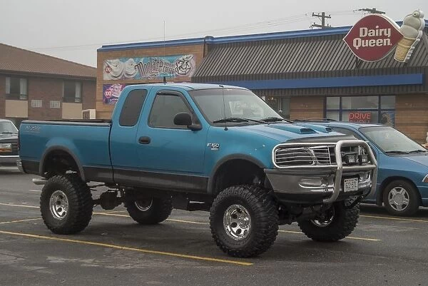 A customized Ford F150 with big wheels and tyres outside a Dairy Queen fast food