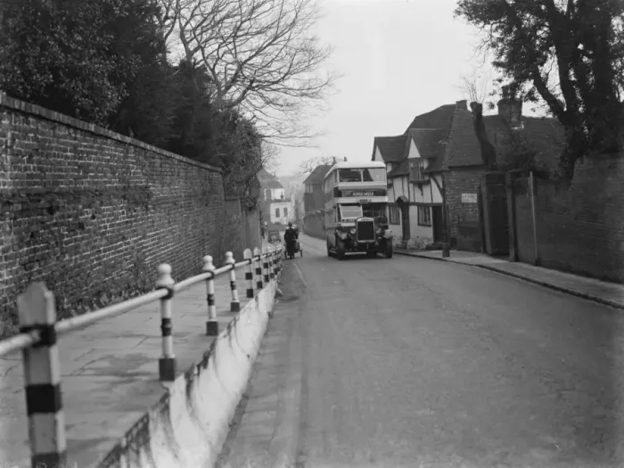 Framed Print : A double decker bus driving past some old cottages on a street in Ashford, Kent