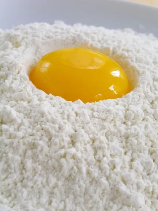 Framed Print : A whole egg yolk broken into a pile of sifted flour credit: Marie-Louise Avery