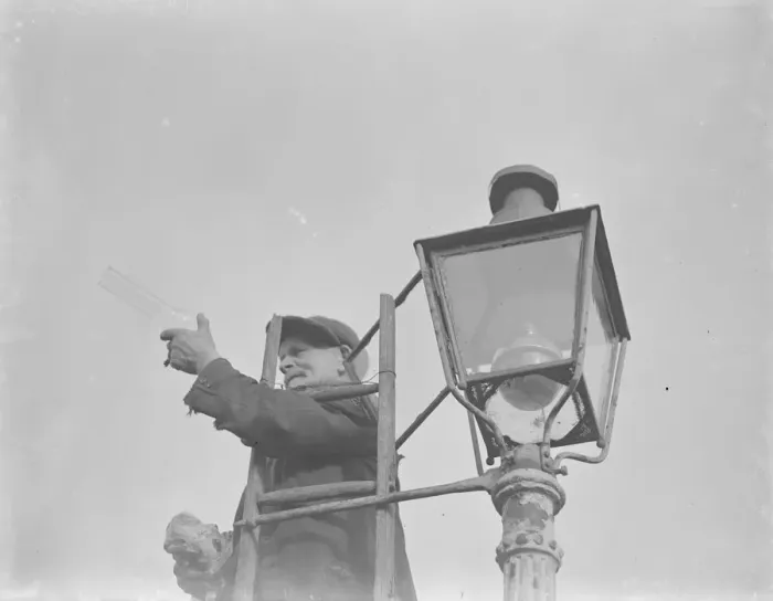 Framed Print : An elderly man lighting an oil street lamp in Hokenden, Kent. 1939
