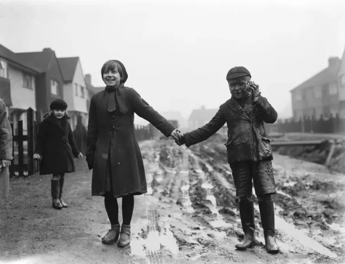 Framed Print : Fen Grove road complaint. A young boy enjoys the mud. 1937