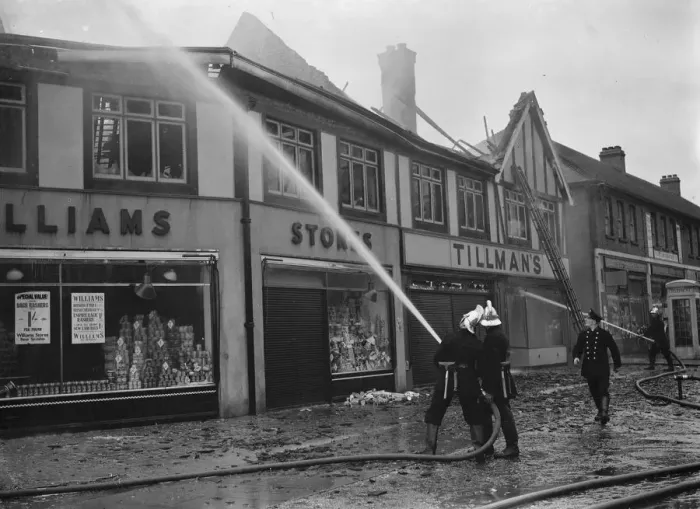 Framed Print : Firemen attempt to put out fires in a parade of shops in Welling, Kent Framed Print : Firemen attempt to put out fires in a parade of shops in Welling, Kent