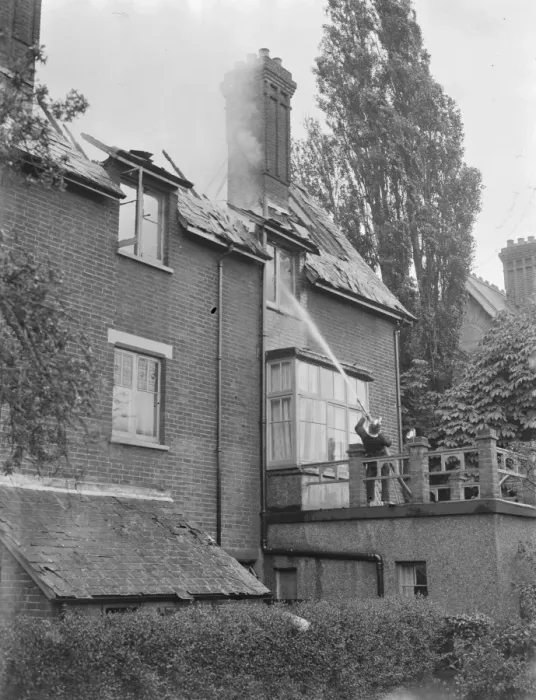 Framed Print : Firemen respond to a house fire in Chislehurst, Kent. A fireman hoses water into Framed Print : Firemen respond to a house fire in Chislehurst, Kent. A fireman hoses water into