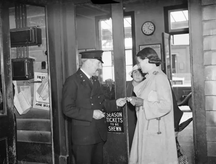 Framed Print : Fred Needham a ticket collector in Dartford, Kent, checking the ticket of a woman Framed Print : Fred Needham a ticket collector in Dartford, Kent, checking the ticket of a woman