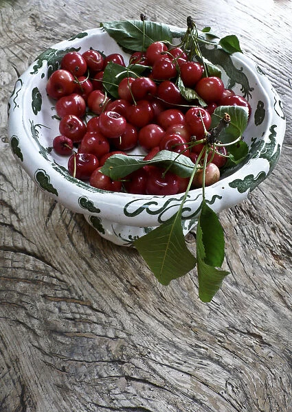Freshly picked cherries from a Kentish garden in decorative pedestal bowl on rustic
