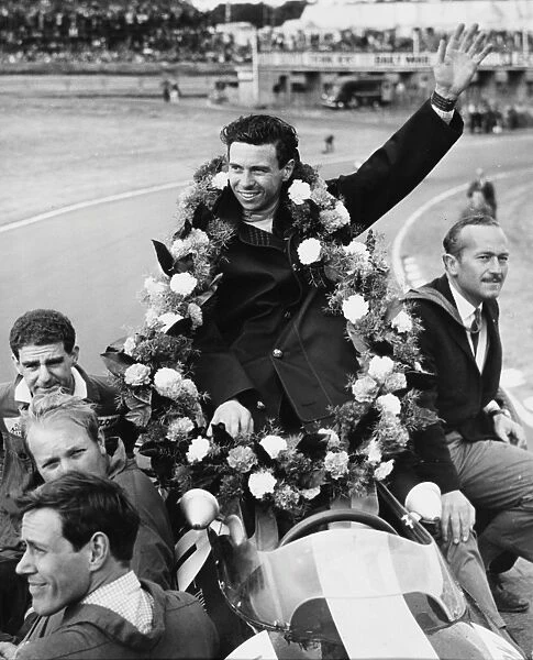 Garlanded Jim Clark. Draped in the victory garland, World Champion Jim Clark of Scotland