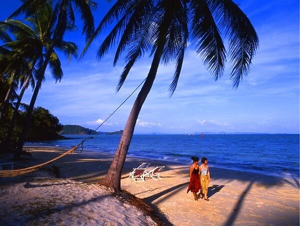 Two girls walking on a beach at Phuket, Cape Phanwa, Thailand