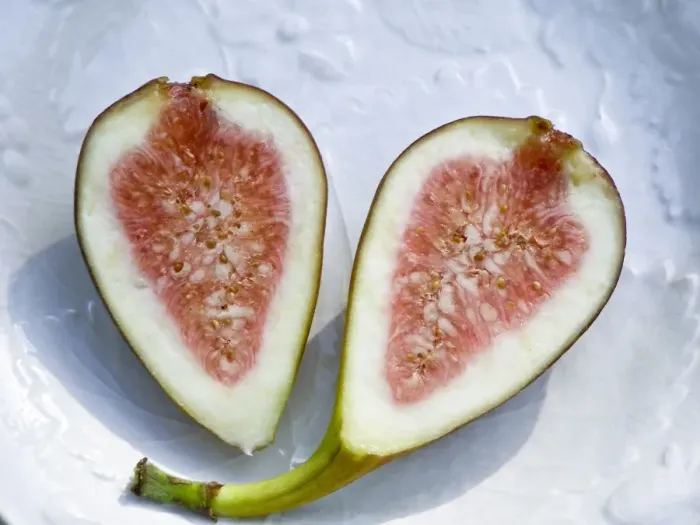 Framed Print : Halved ripe fig on white plate credit: Marie-Louise Avery  /  thePictureKitchen  /  TopFoto