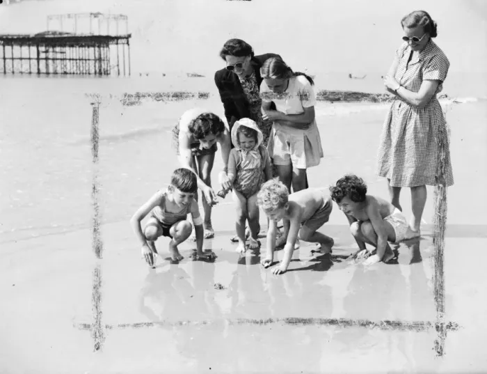 Framed Print : Happy young holidaymakers at St Leonards on Sea show keen interest but keep their Framed Print : Happy young holidaymakers at St Leonards on Sea show keen interest but keep their