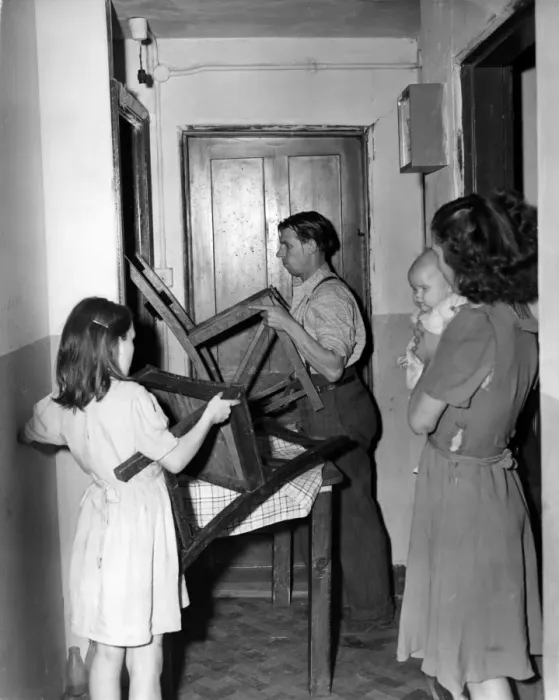 Framed Print : Helped by his 10 yesr old daughter Patricia, Mr Crome barricades the door of his Framed Print : Helped by his 10 yesr old daughter Patricia, Mr Crome barricades the door of his