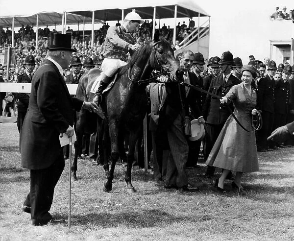 HM Queen Elizabeth II leads her horse Carrozza in after it has won the 179th Oaks Stakes