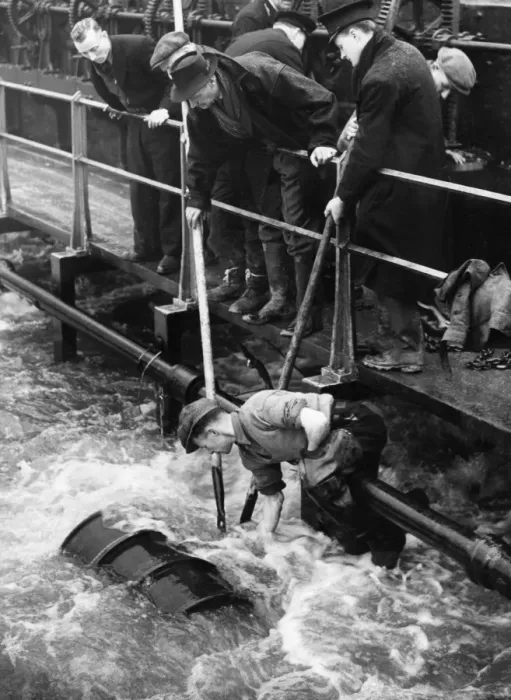 Framed Print : With his legs twisted round a pipe, Jock Kerr of Tottenham worked over the whirling