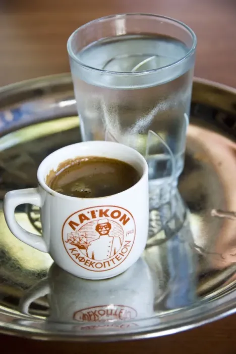 Framed Print : Little cup of strong Greek coffee, with glass of water on tray on table of hillside