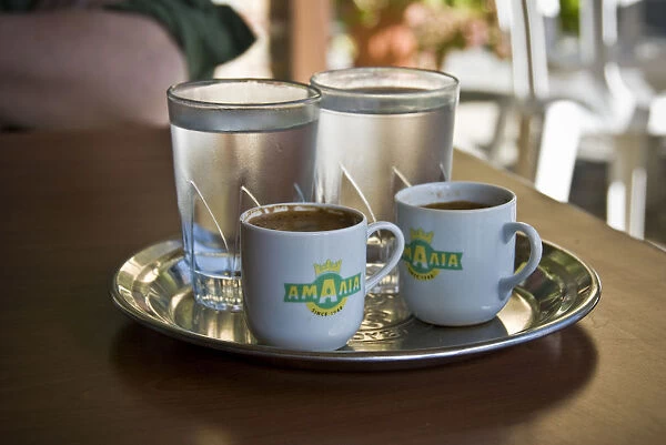 Two little cups of Greek coffee with accompanying glasses of water served in Cypriot