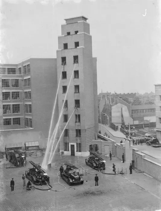 Framed Print : A London Fire Brigade display in Lambeth, London. Firemen hose down from the windows Framed Print : A London Fire Brigade display in Lambeth, London. Firemen hose down from the windows