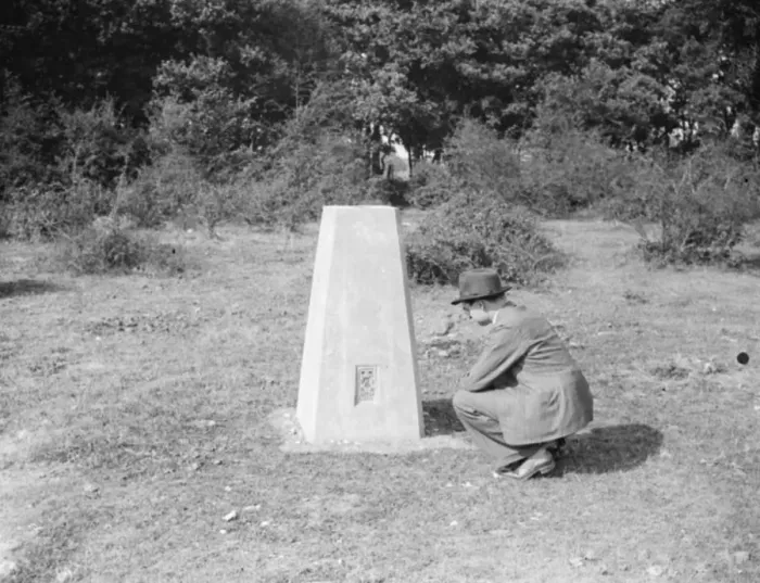 Framed Print : A man crouching at a boundary post in Kemsing, Kent. 1938 Framed Print : A man crouching at a boundary post in Kemsing, Kent. 1938