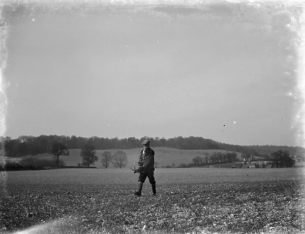Man hand casting seeds on a field. 1936