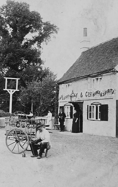 A man with a small cart outside public house at Eversley 1906
