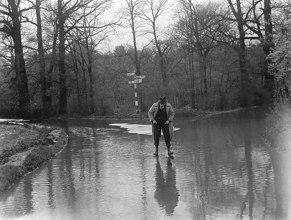 A man walks through the floods in Hockenden, Kent. 1937