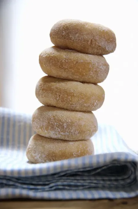 Framed Print : Mini ring doughnuts stacked on blue and white napkin credit: Marie-Louise Avery