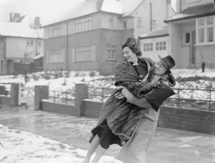 Framed Print : Miss Muriel Oxford is carried over the snow by a young man. 1937 Framed Print : Miss Muriel Oxford is carried over the snow by a young man. 1937