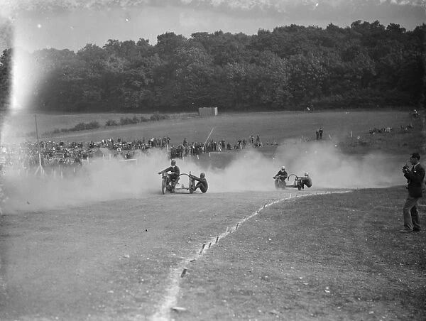 Motor cycling races at Brands Hatch. Two of the side car bikes jostle for position