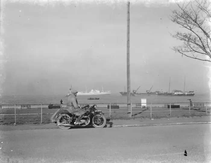 Framed Print : A motorcyclist looks out at the traffic on the Thames estuary from Gravesend promenade