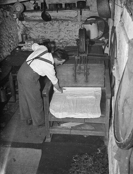 Mr George goodwin operating an old fashion mangle in Meopham. 1938