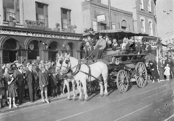 An old stagecoach crammed with passengers rolling down Deptford High Street