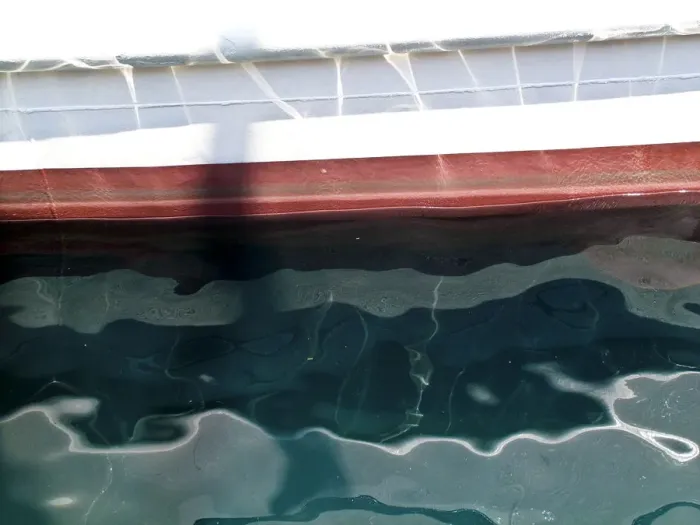 Framed Print : Detail of painted boat at water line showing reflections and ripples credit: Marie-Louise