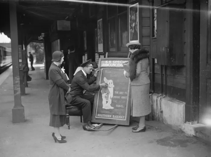 Framed Print : People gather round to watch the railway porter sign writer Mr E A Burgar. 1938 Framed Print : People gather round to watch the railway porter sign writer Mr E A Burgar. 1938